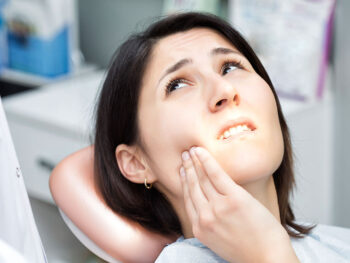 Woman suffering from Dental Implant Complications